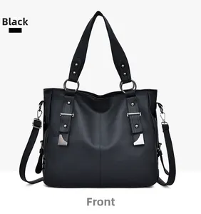 Front detail of black pebble leather tote with silver rings and adjustable strap