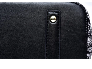 Détail d'un sac à main en cuir noir avec motif python latéral et rivet en métal doré