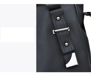 Close-up of black PU leather texture and silver metal rivets on women's handbag