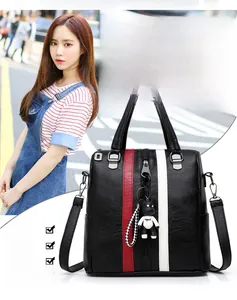 Detail of black PU leather backpack featuring sporty color stripes and a bear charm