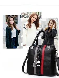 Detail of black leather backpack with grey-red stripes and a cartoon doll pendant