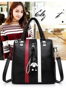 Detail of black PU leather backpack with red white stripes and panda plush charm