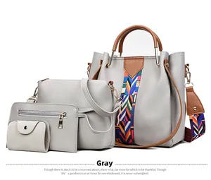 Detail of grey four-piece handbag set featuring a colorful woven strap and brown handles