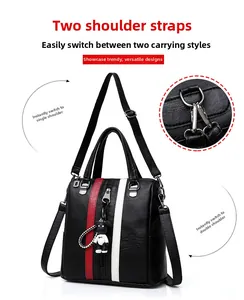 Detail view of black lychee leather backpack with red white stripes and panda charm