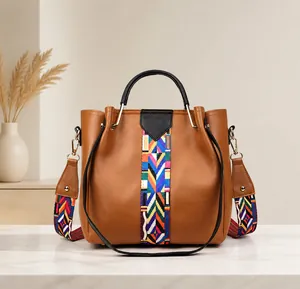 Brown faux leather handbag featuring a vibrant Bohemian woven wide shoulder strap detail