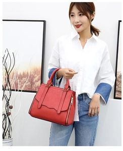 Red PU leather tote bag with dual handles and gold zipper details on a model
