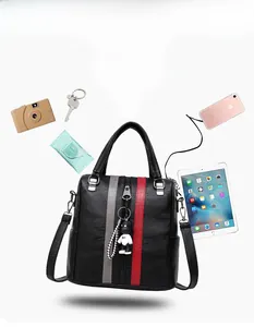 Detail view of black leather handbag capacity with colorful stripes and panda charm