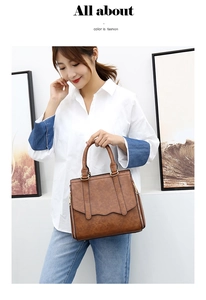 Close-up of brown PU leather handbag featuring side zippers and round top handles