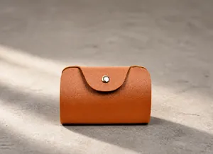 Close-up of brown textured leather card holder with silver metal snap closure