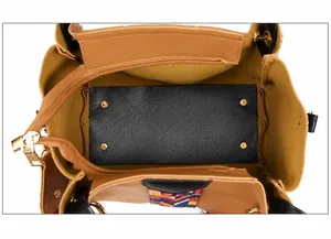 Interior structure of tan leather tote bag with gold zipper and colorful woven strap
