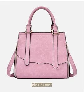 Front view detail of pink crossbody handbag featuring matte texture and wavy flap design