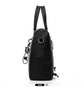 Side view of black pebble leather backpack with checkered strap and metal hardware