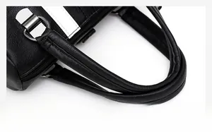 Close-up of black litchi grain leather handle with silver metal rings and white side stripes