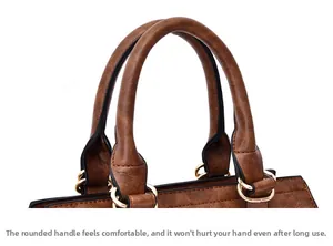 Detail of rounded caramel brown handles with polished gold buckles on a vintage tote bag