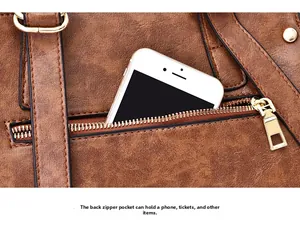 Close-up of a brown textured leather shoulder bag with a functional back zipper pocket