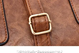 Detail of adjustable gold buckle on brown lychee pattern leather shoulder bag strap