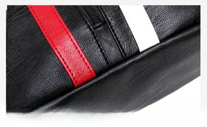 Macro shot of black lychee-textured leather bag with red and white stitched stripe detail