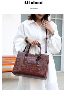 Détail du sac cabas marron à motif crocodile avec garniture dorée et bandoulière