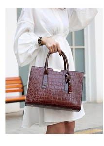 Vue extérieure d'un sac cabas marron à motif crocodile avec plaque en métal doré