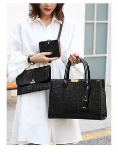 Ensemble de trois sacs noirs motif crocodile avec accessoires dorés portés par un mannequin