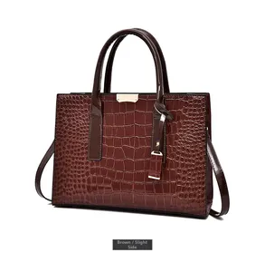 Vue détaillée du sac à main marron motif crocodile avec boucles dorées et doubles anses