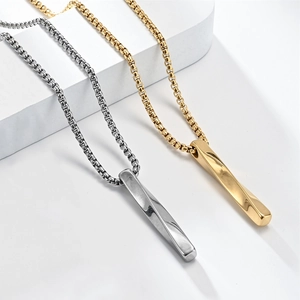 Detailed view of twisted gold and silver bar pendants on box chains with metallic luster