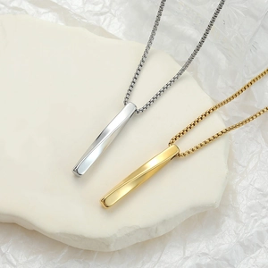 Macro shot of silver and gold rectangular bar pendants on polished box chains