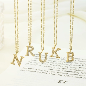 Gros plan de pendentifs alphabet dorés N, R, U, K, B sertis de strass scintillants
