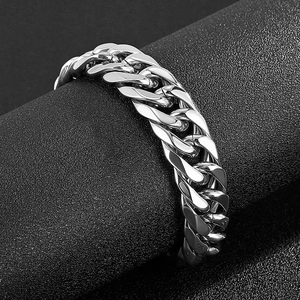 Men's heavy Cuban link bracelet in polished stainless steel on a dark display