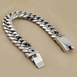 Macro shot of thick silver stainless steel Cuban chain bracelet with heavy clasp