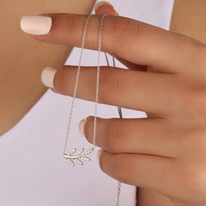 Détail du collier pendentif feuille en acier titane avec cristaux de zircone brillants