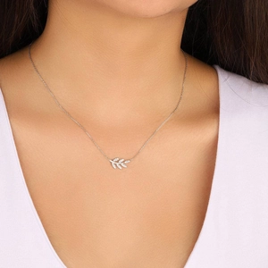 Collier branche d'olivier argentée avec zircons porté par une femme sur fond blanc