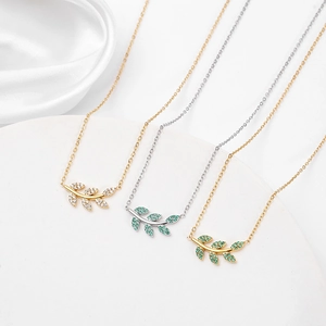 Détails de trois colliers en forme de branche de feuilles en or et argent avec zircons