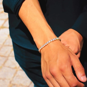Gros plan d'un bracelet tennis plaqué or avec zircons brillants au poignet du mannequin