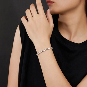 Primo piano di un bracciale tennis in argento con zirconi a forma di cuore al polso