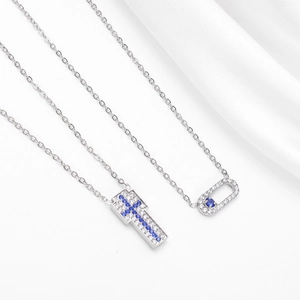 Collier avec pendentif croix et ovale en acier titane argenté serti de cristaux