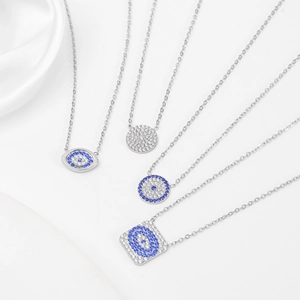 Detailed close-up of four silver evil eye necklaces with blue and white cubic zirconia