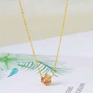 Vue macro du collier en acier inoxydable doré 18 carats avec pendentif zircon champagne