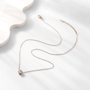 Vue macro d'un collier en acier inoxydable plaqué or 18K avec pendentif zircon 6 griffes