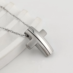Detail of silver double-layered cross pendant with brushed and polished steel finish