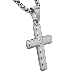 Detail of silver cross pendant with a central cubic zirconia on a box chain link