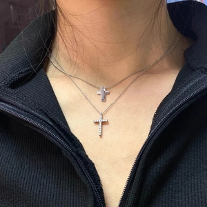 Layered silver cross pendant necklaces for men and women on black sweater