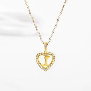 Détail d'un pendentif coeur doré serti de zircons avec la lettre I au centre