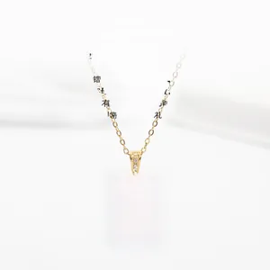 Close-up of golden letter K pendant necklace with sparkling white cubic zirconia stones