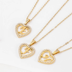 Collier avec pendentif cœur doré serti de cristaux et design de lettre évidée