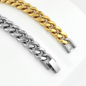 Detailed macro view of gold and silver stainless steel Cuban links with fold-over clasps