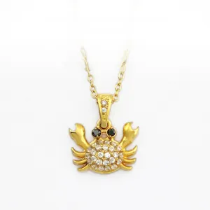 Detailed close-up of a golden crab pendant necklace with sparkling zircon pavé setting