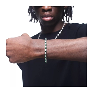 Gros plan d'un bracelet tennis en argent avec zircons vert émeraude et clairs