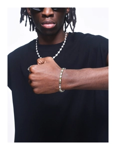 Détail d'un bracelet tennis en argent avec zircons verts carrés sertis à griffes