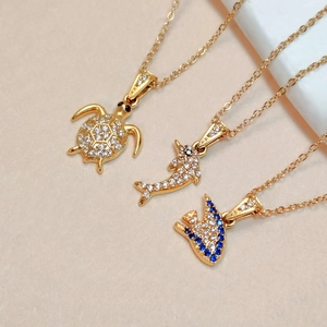 Gold-plated ocean theme necklaces featuring turtle and dolphin charms with blue zircon